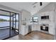 Modern white kitchen offers views of a screened-in patio and backyard lake at 75 Inlets Blvd # 75, Nokomis, FL 34275