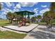 Community playground with shade structure and slide, surrounded by picturesque palm trees at 75 Inlets Blvd # 75, Nokomis, FL 34275