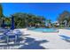 Wide angle shot of the community pool with blue umbrellas and lounge chairs at 75 Inlets Blvd # 75, Nokomis, FL 34275