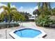 Community pool with a covered hot tub and lush tropical landscaping at 75 Inlets Blvd # 75, Nokomis, FL 34275