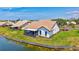 Rear exterior view of white home with screened lanai and lake at 75 Inlets Blvd # 75, Nokomis, FL 34275