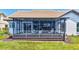 Screened lanai with table and chairs overlooking the yard at 75 Inlets Blvd # 75, Nokomis, FL 34275