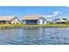 Back of property with peaceful water view, screened lanai, and green grass at 75 Inlets Blvd # 75, Nokomis, FL 34275