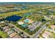 An aerial view of a community with tennis courts, a pool, and ponds at 7574 Camden Harbour Dr, Bradenton, FL 34212
