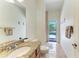 Bathroom with stone counters, single vanity, shower and access to pool area at 7574 Camden Harbour Dr, Bradenton, FL 34212