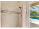 Shower with tile surround and access to the pool area at 7574 Camden Harbour Dr, Bradenton, FL 34212