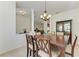 Formal dining room with decorative lighting and seating for six adjoins a butler's pantry and living spaces at 7574 Camden Harbour Dr, Bradenton, FL 34212