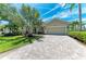 Well-manicured front yard with a paver driveway leading to a two-car garage at 7574 Camden Harbour Dr, Bradenton, FL 34212