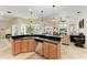 Kitchen island with sink, breakfast bar, granite counters and stainless appliances open to the living area at 7574 Camden Harbour Dr, Bradenton, FL 34212