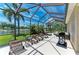 Spacious screened lanai featuring comfortable lounge chairs, a grill and serene lake views at 7574 Camden Harbour Dr, Bradenton, FL 34212