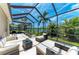 Covered lanai with comfortable lounge furniture and beautiful landscaping overlooking the lake at 7574 Camden Harbour Dr, Bradenton, FL 34212