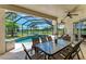 Outdoor dining area on the lanai overlooking a pool, spa and peaceful water view at 7574 Camden Harbour Dr, Bradenton, FL 34212