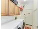 The laundry room has wooden cabinets, a sink, a washer, and a dryer at 7574 Camden Harbour Dr, Bradenton, FL 34212