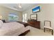 Bright main bedroom features a ceiling fan, TV, dresser, and access to the lanai through a sliding glass door at 7574 Camden Harbour Dr, Bradenton, FL 34212