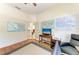 Bright home office/den features hardwood floors, maps, and a comfortable seating area for productivity at 7574 Camden Harbour Dr, Bradenton, FL 34212