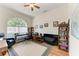 Office/den has an arched window, ceiling fan, hardwood floors, and room for a desk, shelving, and TV area at 7574 Camden Harbour Dr, Bradenton, FL 34212