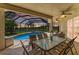 Covered patio featuring outdoor seating and ceiling fans overlooking a screened-in pool and lake at 7574 Camden Harbour Dr, Bradenton, FL 34212