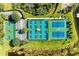 Aerial view showcasing community tennis and pickleball courts, surrounded by lush landscaping and a tranquil pond at 7574 Camden Harbour Dr, Bradenton, FL 34212