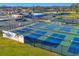 Aerial view showcasing numerous tennis and pickle ball courts at Palm Aire Country Club at 7724 Palm Aire Ln, Sarasota, FL 34243