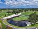 Aerial view of the lush golf course, a water feature and bridge at 7724 Palm Aire Ln, Sarasota, FL 34243