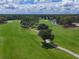 Beautiful aerial view of the lush green golf course and the manicured walking paths, lake, and natural foliage at 7724 Palm Aire Ln, Sarasota, FL 34243
