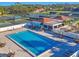Aerial view of the tennis and pool with palm trees and other lush greenery at 7724 Palm Aire Ln, Sarasota, FL 34243