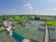 Overhead shot of the tennis courts, including numerous green courts and clear blue skies at 7724 Palm Aire Ln, Sarasota, FL 34243