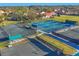 Aerial view of community tennis and pickle ball courts surrounded by lush greenery at 7724 Palm Aire Ln, Sarasota, FL 34243