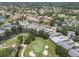 A panoramic aerial view of a residential neighborhood, golf course, and scenic landscape, highlighting the community's amenities at 7724 Palm Aire Ln, Sarasota, FL 34243