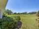 Spacious backyard with lush green grass and mature trees, perfect for outdoor activities and relaxation at 7724 Palm Aire Ln, Sarasota, FL 34243