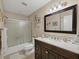 Clean bathroom with a vanity, framed mirror, and a shower-tub combination with sliding glass doors at 7724 Palm Aire Ln, Sarasota, FL 34243