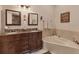 Elegant bathroom features a double vanity with granite counters, corner soaking tub, and neutral tile at 7724 Palm Aire Ln, Sarasota, FL 34243