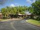 Exterior view of the property with tile roof, featuring a circular driveway and well-maintained landscaping at 7724 Palm Aire Ln, Sarasota, FL 34243