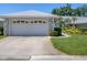 Two car garage featuring a decorative white garage door and professional landscaping at 7724 Palm Aire Ln, Sarasota, FL 34243