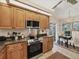 A well-equipped kitchen with a cooktop, dark countertops, light wood cabinets, and eat-in nook at 7724 Palm Aire Ln, Sarasota, FL 34243