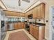 A well-lit kitchen with stainless steel appliances, light wood cabinets, and a neutral-toned floor at 7724 Palm Aire Ln, Sarasota, FL 34243