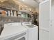 Organized laundry room features side-by-side washer and dryer, overhead shelving, and storage at 7724 Palm Aire Ln, Sarasota, FL 34243
