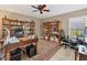 Spacious home office with hardwood bookcases, a large desk, and room for dual workstations at 7724 Palm Aire Ln, Sarasota, FL 34243