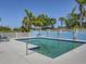 Community pool with ample seating, surrounded by a privacy fence and lush landscaping for a relaxing experience at 7724 Palm Aire Ln, Sarasota, FL 34243