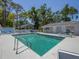 A welcoming community pool surrounded by lounge chairs, tables, and lush landscaping, ideal for relaxation and recreation at 7724 Palm Aire Ln, Sarasota, FL 34243