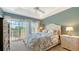 Inviting bedroom with balcony access, tray ceiling, and a soft, floral comforter at 9008 White Sage Loop # 3605, Lakewood Ranch, FL 34202