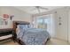 Bright bedroom with a wicker headboard, blue bedding, and natural light from the window at 9008 White Sage Loop # 3605, Lakewood Ranch, FL 34202