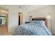 Bright bedroom features a wicker headboard, blue bedding, and hall access at 9008 White Sage Loop # 3605, Lakewood Ranch, FL 34202
