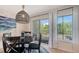 Bright dining area with a view to the outdoors through sliding glass doors and modern hanging light fixture at 9008 White Sage Loop # 3605, Lakewood Ranch, FL 34202