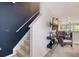 Relaxing living room showcasing a wicker chair, wall-mounted TV, and staircase at 9008 White Sage Loop # 3605, Lakewood Ranch, FL 34202