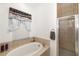 Bright bathroom with a soaking tub, glass-enclosed shower, and decorative window at 9101 Yarberry St, Sarasota, FL 34240