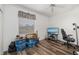 Bedroom features wood floors, storage containers, guitar, TV with beach screen saver, chair and ceiling fan at 9101 Yarberry St, Sarasota, FL 34240