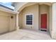 View of front entrance featuring a red door, neutral paint, and large columns with sidelight windows at 9101 Yarberry St, Sarasota, FL 34240