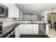 Modern kitchen boasts stainless appliances, white cabinets, mosaic tile backsplash, and black countertop at 9101 Yarberry St, Sarasota, FL 34240