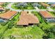 Expansive aerial view of a well-manicured home with a tile roof and lush green lawn, nestled in a beautiful neighborhood at 9734 Carnoustie Pl, Bradenton, FL 34211